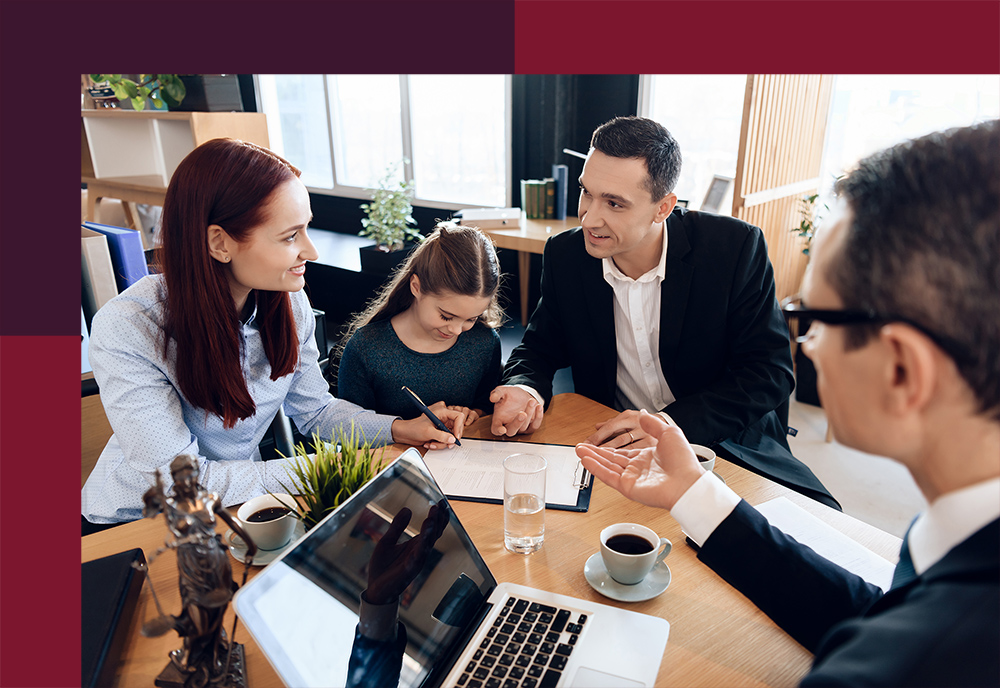 Lawyer shows mother where to sign documents while small daughter and husband are sitting beside.
