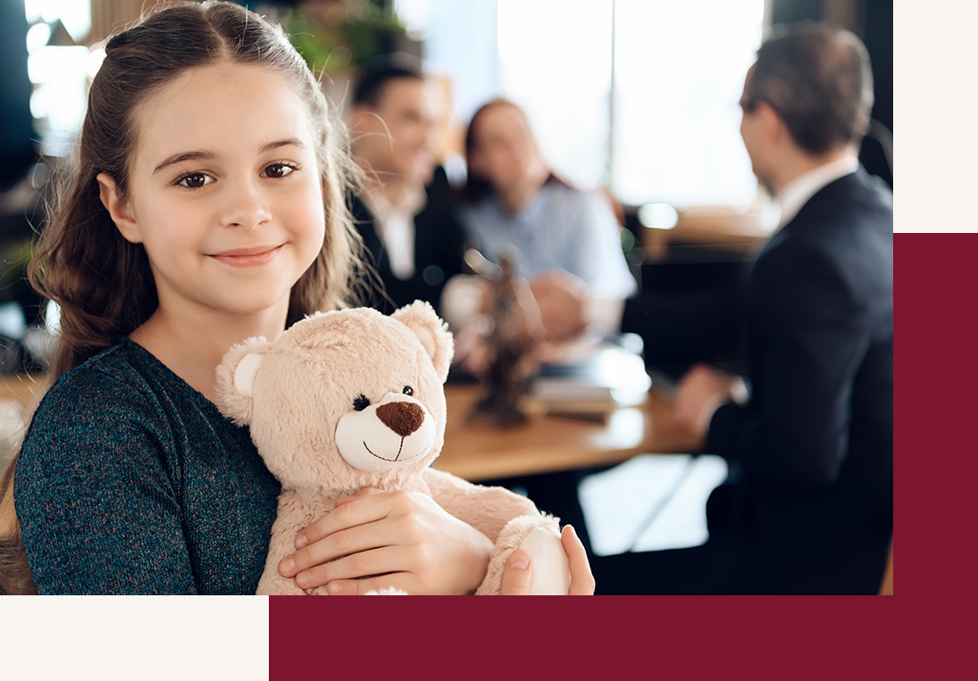 Happy little girl is hugging teddy bear at office of family lawyer. Registration of guardianship.